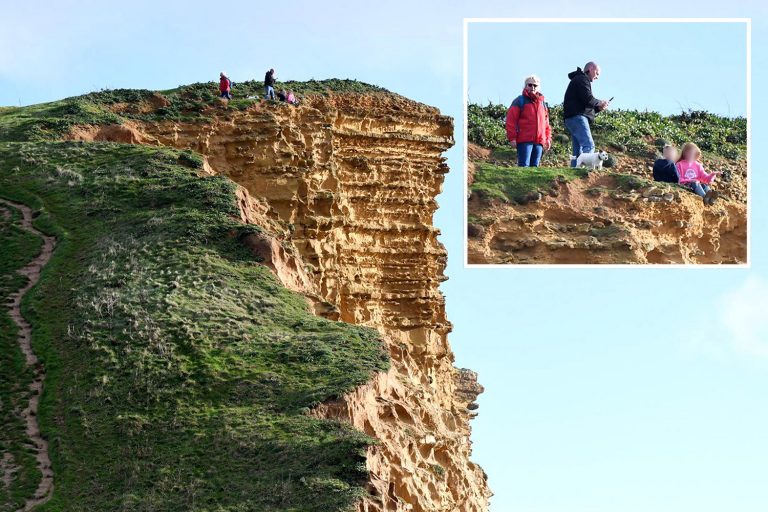 Shocking moment young kids dangle over 150ft rocky Broadchurch cliff as ‘dad’ takes pic